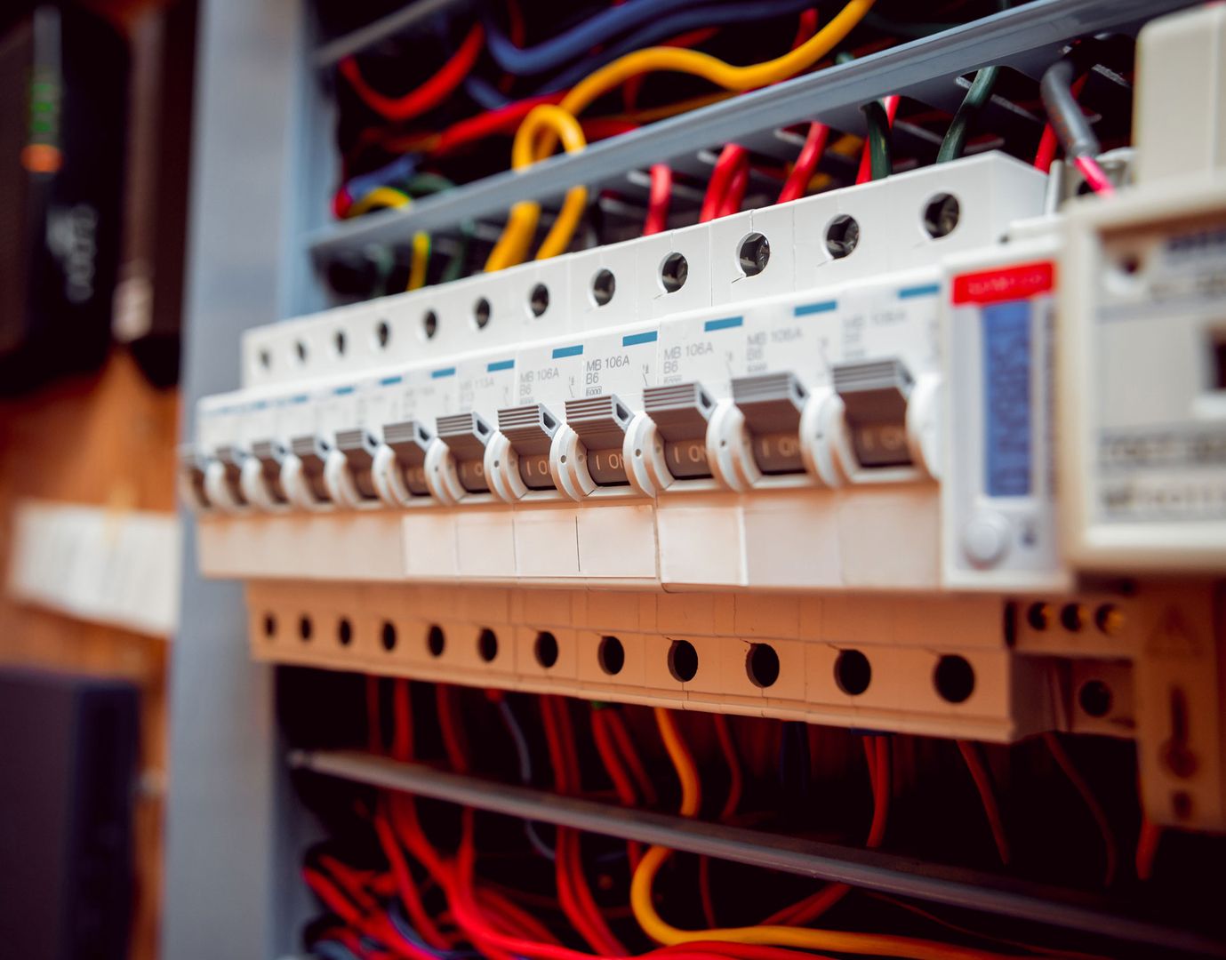 Nahaufnahme von Leitungsschutzschaltern im Stromkasten mit farbigen Kabeln - Sicherungsverteiler einer Elektroanlage